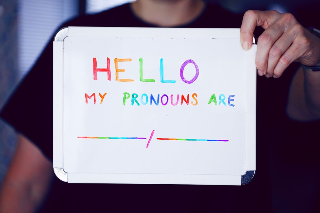 teenager holding sign pronouns